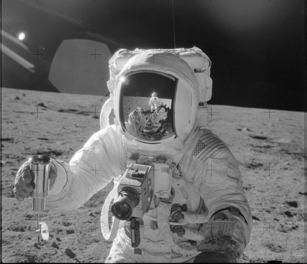 NASA photo of astronaut in spacesuit on lunar surface with camera mounted to chest