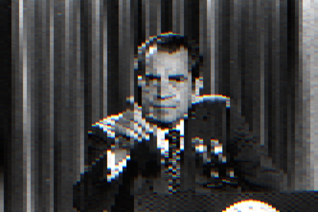 pixelated photograph of President Nixon at a lectern pointing at someone in the crowd